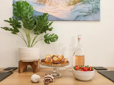 a table with a plate of food and wine glasses at Lighthouse Lofts - St Anthony in Camborne