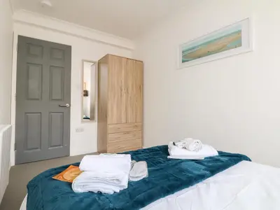 a bedroom with a bed with towels on it at Lighthouse Lofts - St Anthony in Camborne