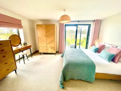 a bedroom with a bed and a desk and a window at Avalennek in Newquay