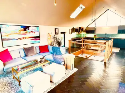 a living room with a couch and a kitchen at Avalennek in Newquay