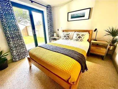a bedroom with a bed and a large window at Avalennek in Newquay