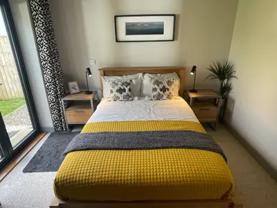 a bedroom with a bed with a yellow blanket at Avalennek in Newquay