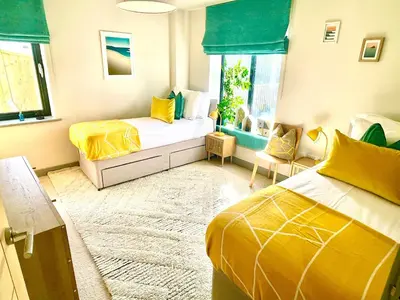 a bedroom with two beds and a window at Avalennek in Newquay