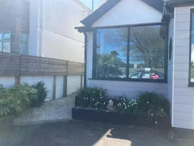 a window on the side of a house with plants at The Salt Box- Lovely refurbished annexe, free parking, walk to Porth beach. in Saint Columb Minor