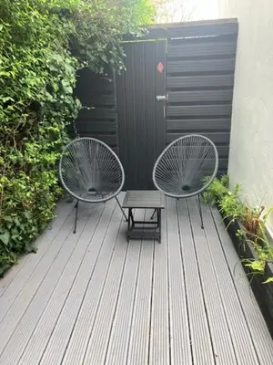 two chairs and a bench sitting on a deck at The Salt Box- Lovely refurbished annexe, free parking, walk to Porth beach. in Saint Columb Minor