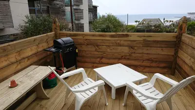 a patio with a table and chairs and a grill at Surf Lookout - King size en-suite with sea views in Newquay