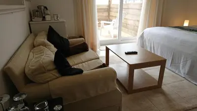 a living room with a couch and a table and a bed at Surf Lookout - King size en-suite with sea views in Newquay