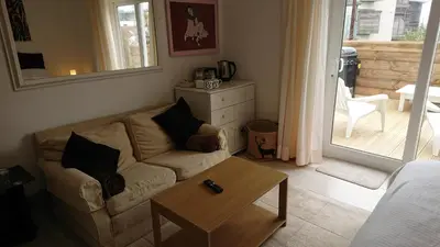 a living room with a couch and a table at Surf Lookout - King size en-suite with sea views in Newquay