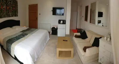 a bedroom with a bed and a couch at Surf Lookout - King size en-suite with sea views in Newquay