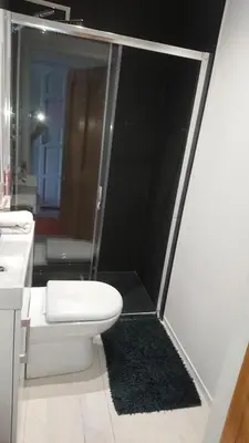 a bathroom with a shower with a toilet and a sink at Surf Lookout - King size en-suite with sea views in Newquay