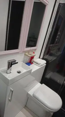 a bathroom with a white sink and a toilet at Surf Lookout - King size en-suite with sea views in Newquay