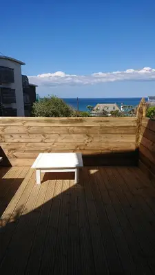 a white bench sitting on top of a wooden deck at Surf Lookout - King size en-suite with sea views in Newquay