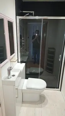 a man taking a picture of a bathroom with a toilet at Surf Lookout - King size en-suite with sea views in Newquay