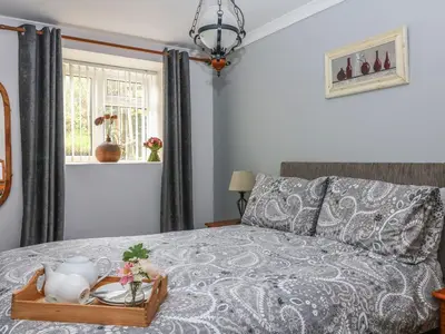 a bedroom with a bed with a tray with a tea set on it at The Retreat in Liskeard