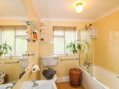 a bathroom with a sink and a toilet and a tub at The Retreat in Liskeard