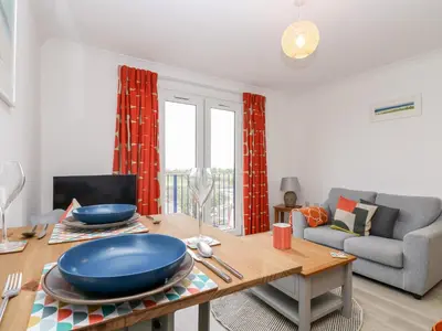 a living room with a table and a couch at Azure in St Ives