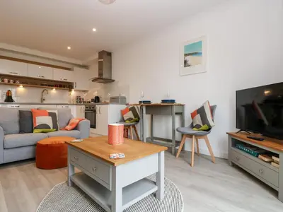 a living room with a couch and a tv at Azure in St Ives