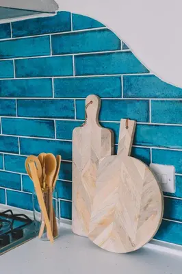 a wooden cutting board next to a brick wall at Pentire Point - Fully Equipped Eco Escape in Crantock