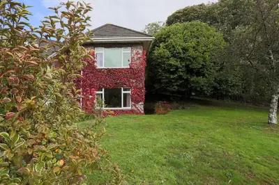 a red brick house with white windows in a yard at Truro apartment in a stunning quiet location in Truro