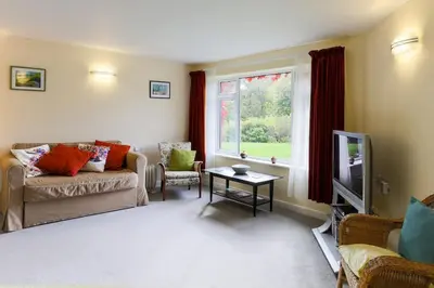 a living room with a couch and a table and a window at Truro apartment in a stunning quiet location in Truro