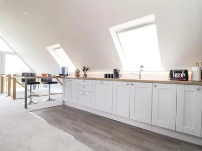 a kitchen with white cabinets and a large window at Higher Kernick View in Bodmin