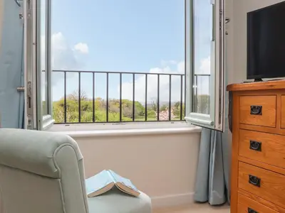 a living room with a tv and a window at Higher Kernick View in Bodmin