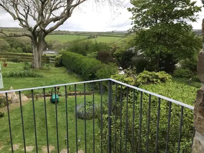 a wrought iron fence in a yard with a garden at Cozy Camborne Studio Retreat with two single beds in Camborne