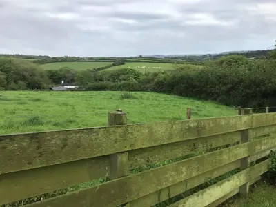 a fence with a view of a green field at Cozy Camborne Studio Retreat with two single beds in Camborne
