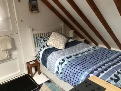 a small bedroom with a bed in a attic at Cozy Camborne Studio Retreat with two single beds in Camborne