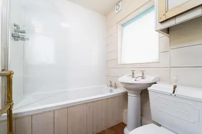 a bathroom with a tub and a sink and a toilet at Secret Cottage in St Ives