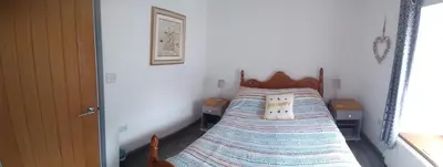 a bedroom with a bed with a wooden head board at Sam's retreat in Hayle