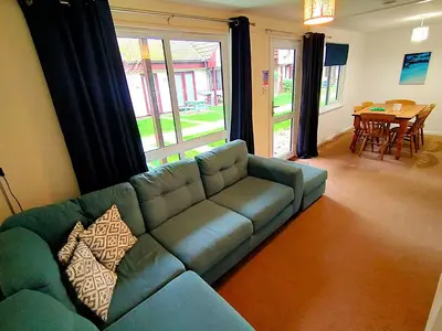 a living room with a blue couch and a table at Trevithick Cottage Sleeps 6 Dog Friendly Parking in Hayle