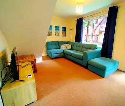 a living room with a blue couch and a tv at Trevithick Cottage Sleeps 6 Dog Friendly Parking in Hayle