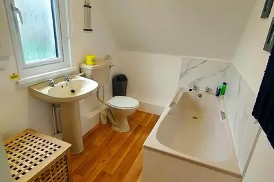 a white bathroom with a toilet and a sink at Trevithick Cottage Sleeps 6 Dog Friendly Parking in Hayle