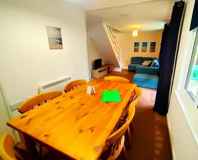 a wooden table and chairs in a living room at Trevithick Cottage Sleeps 6 Dog Friendly Parking in Hayle