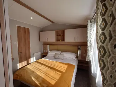 a small bedroom with a bed in a room at White Acre's Holiday Park, 602 Sycamore Forest in Saint Enoder