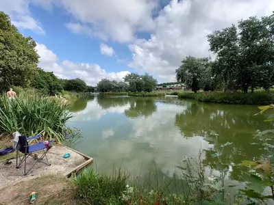 a person sitting in a chair next to a river at White Acre's Holiday Park, 602 Sycamore Forest in Saint Enoder