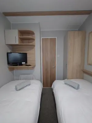 two beds in a small room with a tv at White Acre's Holiday Park, 602 Sycamore Forest in Saint Enoder