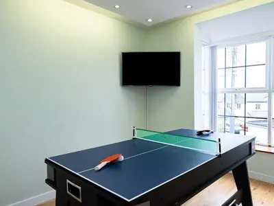 a ping pong table in a room with a tv at Lamorna in Port Isaac