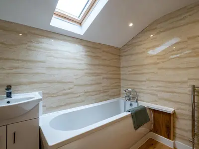 a bathroom with a bath tub and a sink at Lamorna in Port Isaac