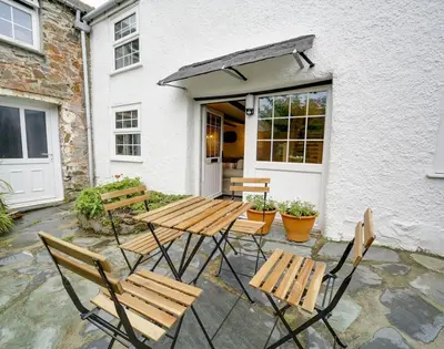a picnic table and chairs in front of a building at Dane Cottage in Port Isaac