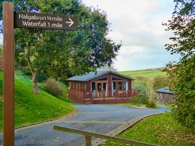 a sign in front of a house with a building at 23 Bossiney Bay in Tintagel