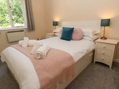 a bedroom with two beds and a window at Blackbird Cottage in Falmouth