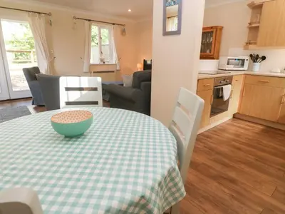 a kitchen and living room with a table with a bowl on it at Blackbird Cottage in Falmouth