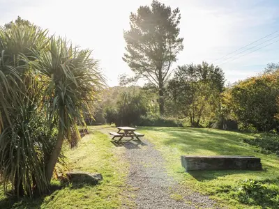 a picnic table in the middle of a field at Blackbird Cottage in Falmouth
