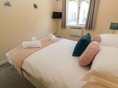 a bedroom with two beds with towels on them at Blackbird Cottage in Falmouth