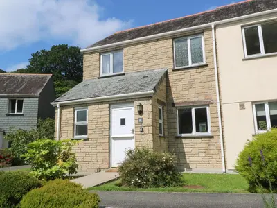 a brick house with a white door at Blackbird Cottage in Falmouth