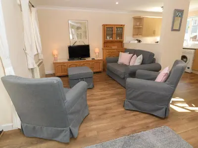 a living room with two couches and a tv at Blackbird Cottage in Falmouth
