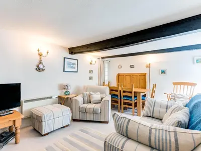 a living room with a couch and chairs and a television at Temple Cottage in Port Isaac