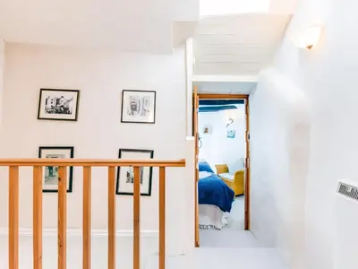 a staircase in a house with white walls at Temple Cottage in Port Isaac